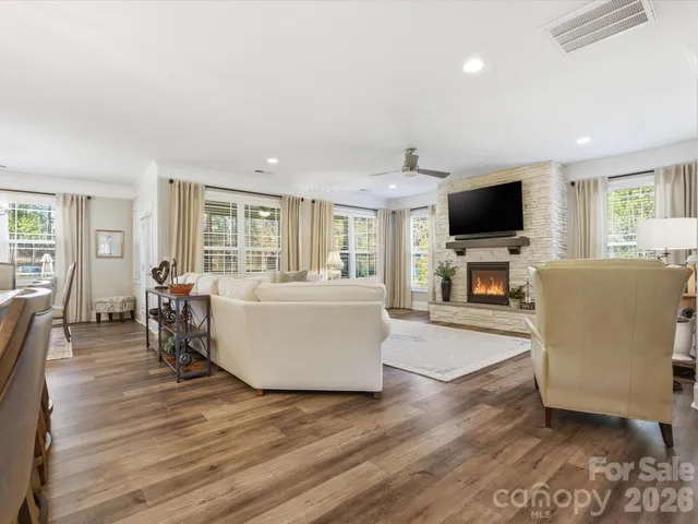 a living room with furniture a fireplace and a flat screen tv