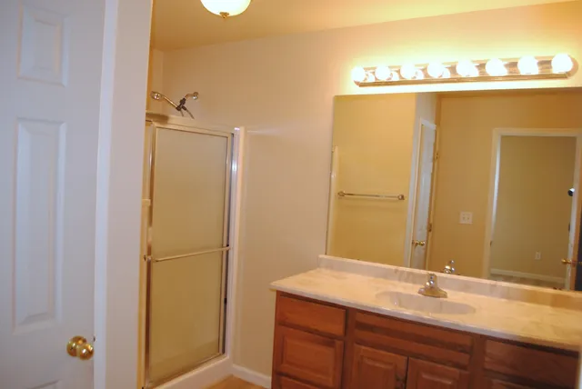 a bathroom with a granite countertop sink and a mirror