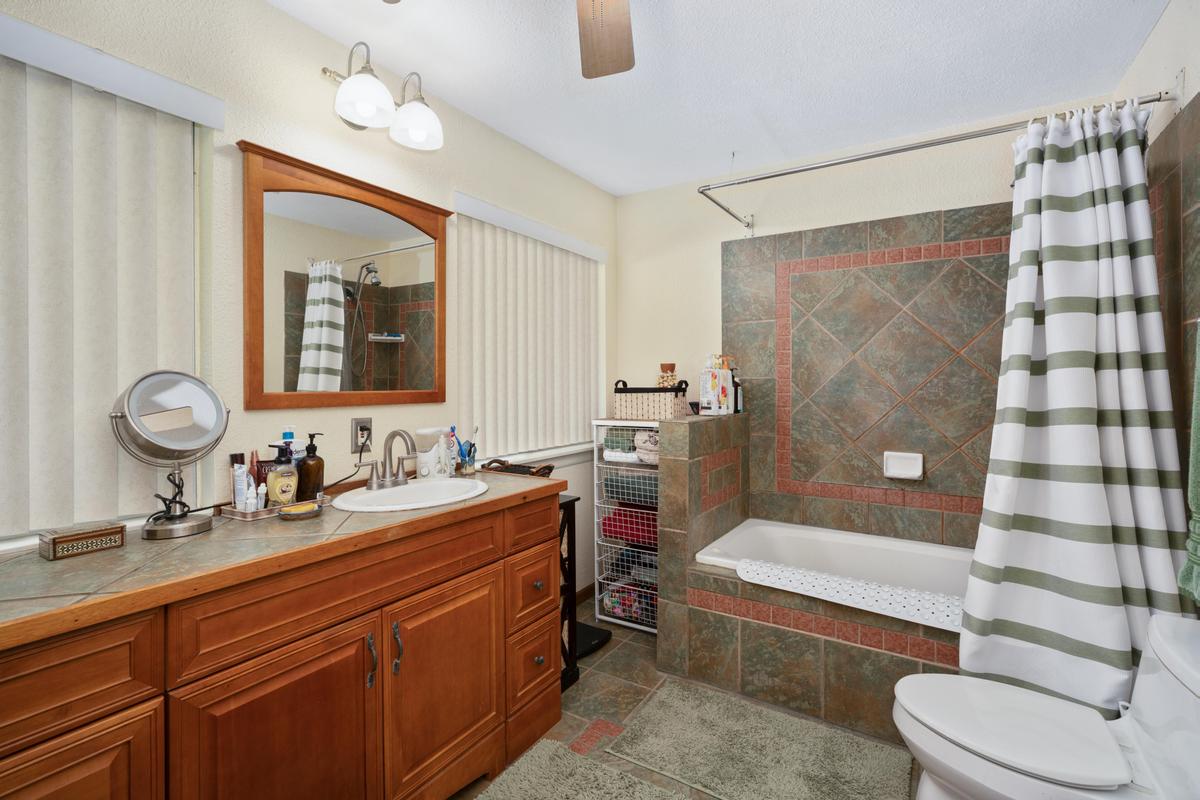 85-4563 Hawaii Belt Road Captain Cook, HI 96704 - Photo 18 of 30 a bathroom with a double vanity sink toilet mirror and shower