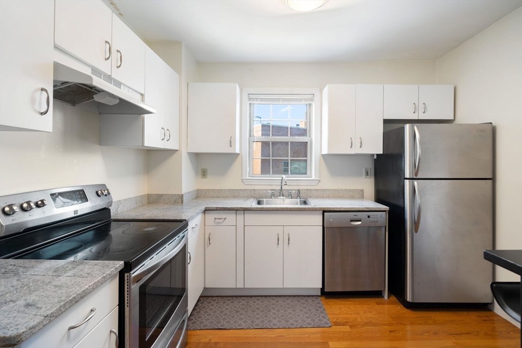 251 Roxbury Street, Unit 2 Boston, MA 02119 - Photo 1 of 16 a kitchen with stainless steel appliances granite countertop a sink stove and refrigerator