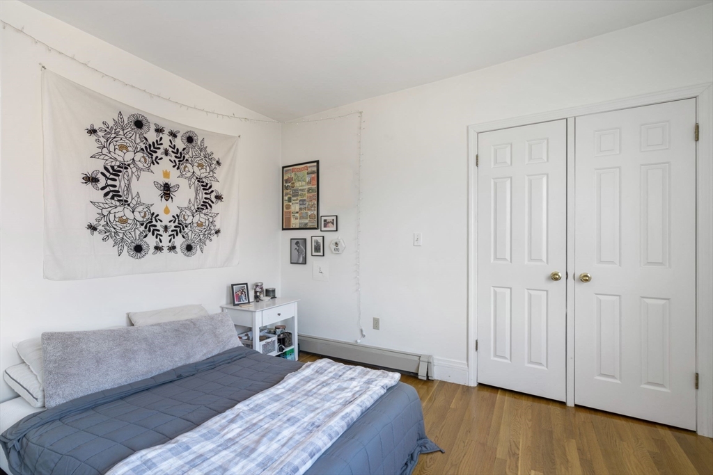 251 Roxbury Street, Unit 2 Boston, MA 02119 - Photo 12 of 16 a bedroom with a bed and a couch