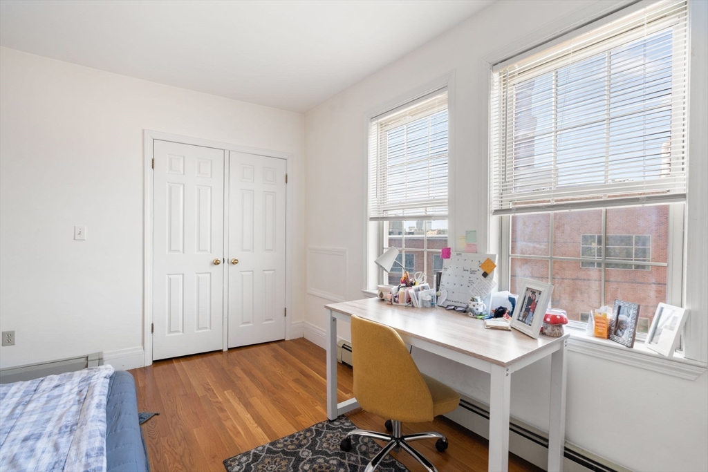 251 Roxbury Street, Unit 2 Boston, MA 02119 - Photo 13 of 16 a bedroom with a bed and a table in it