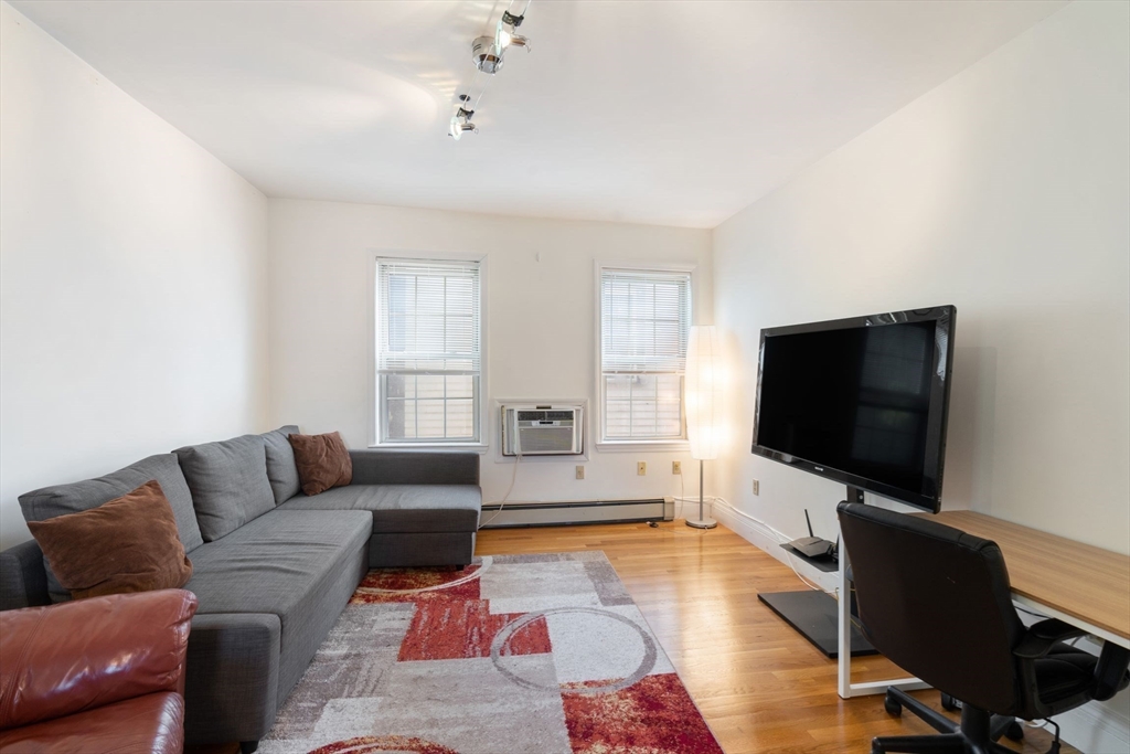 251 Roxbury Street, Unit 2 Boston, MA 02119 - Photo 6 of 16 a living room with furniture and a flat screen tv