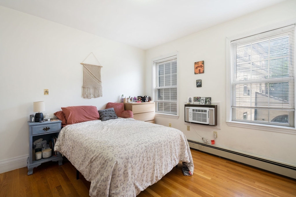 251 Roxbury Street, Unit 2 Boston, MA 02119 - Photo 8 of 16 a bedroom with a bed and wooden floor