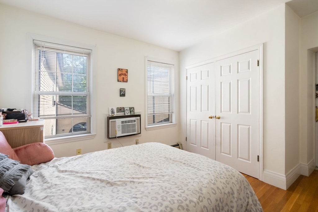 251 Roxbury Street, Unit 2 Boston, MA 02119 - Photo 10 of 16 a bedroom with a bed and wooden floor