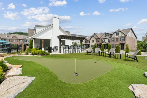 a view of a white house with a big yard and potted plants