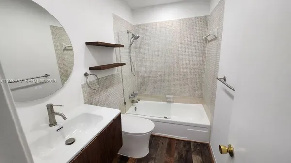 a bathroom with a bathtub shower sink vanity and toilet