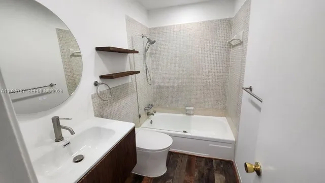 a bathroom with a bathtub shower sink vanity and toilet