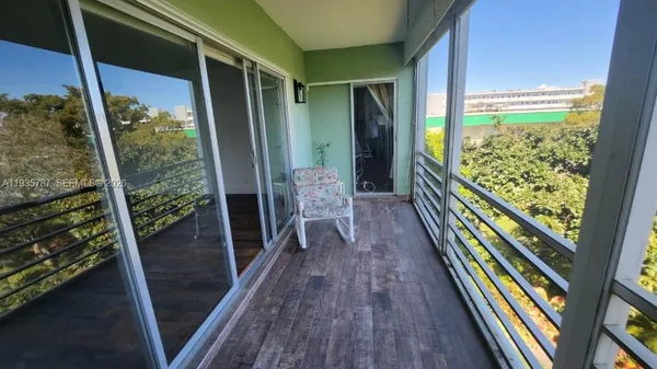 a balcony with chairs and wooden floor