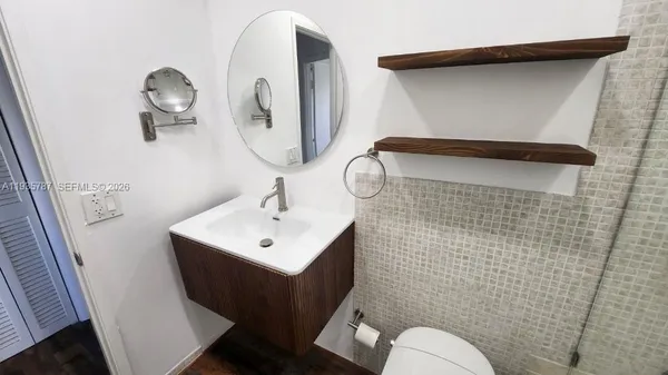 a bathroom with a toilet sink and mirror