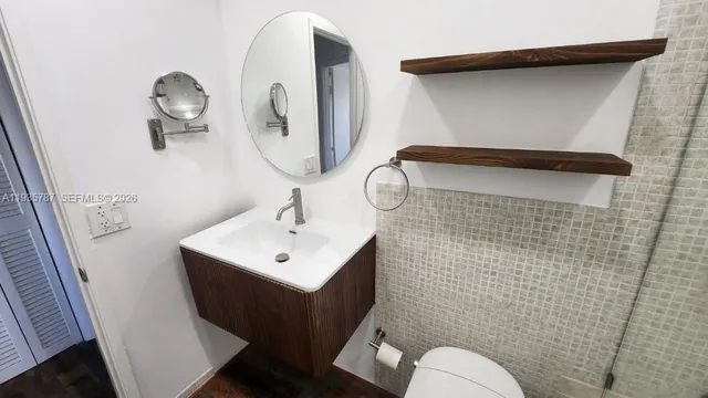 a bathroom with a toilet sink and mirror