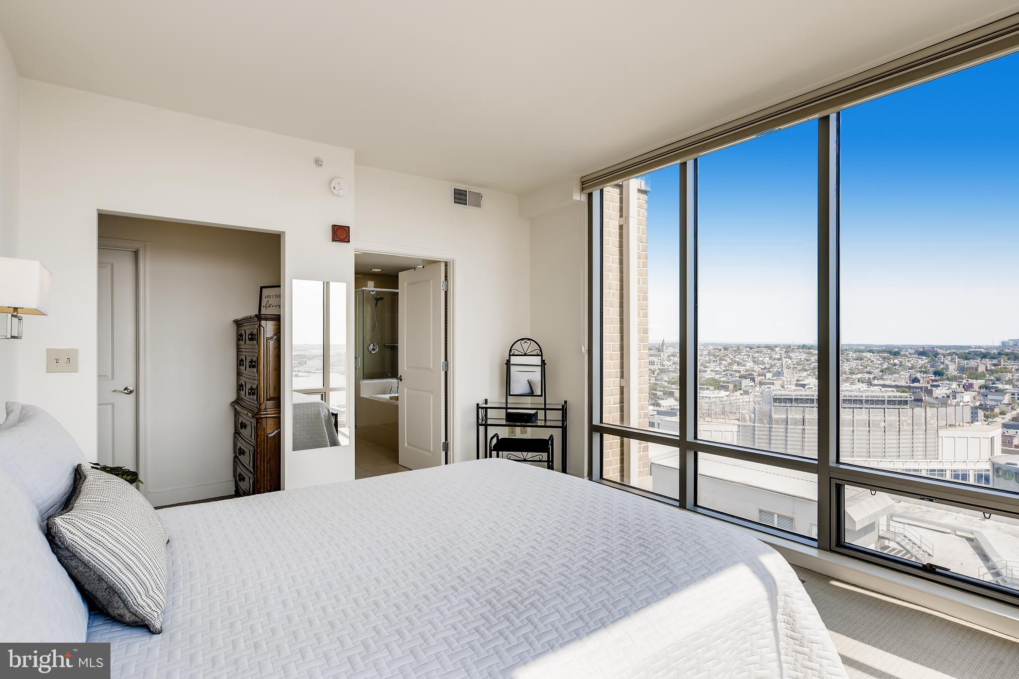 675 President Street, Unit 2105 Baltimore, MD 21202 - Photo 17 of 40 a bedroom with a large bed and a large window