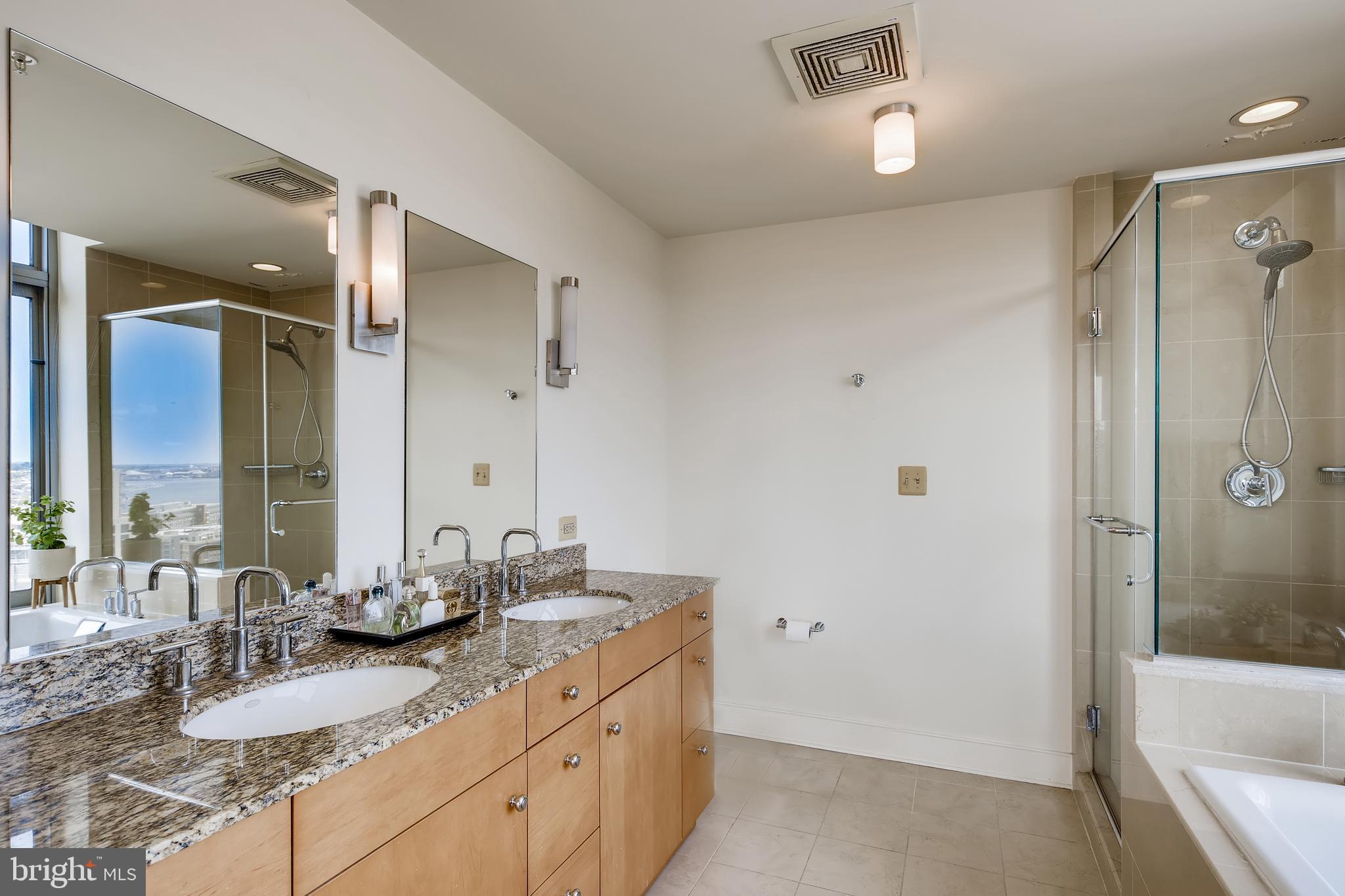 675 President Street, Unit 2105 Baltimore, MD 21202 - Photo 18 of 40 a bathroom with a granite countertop sink mirror and a bathtub