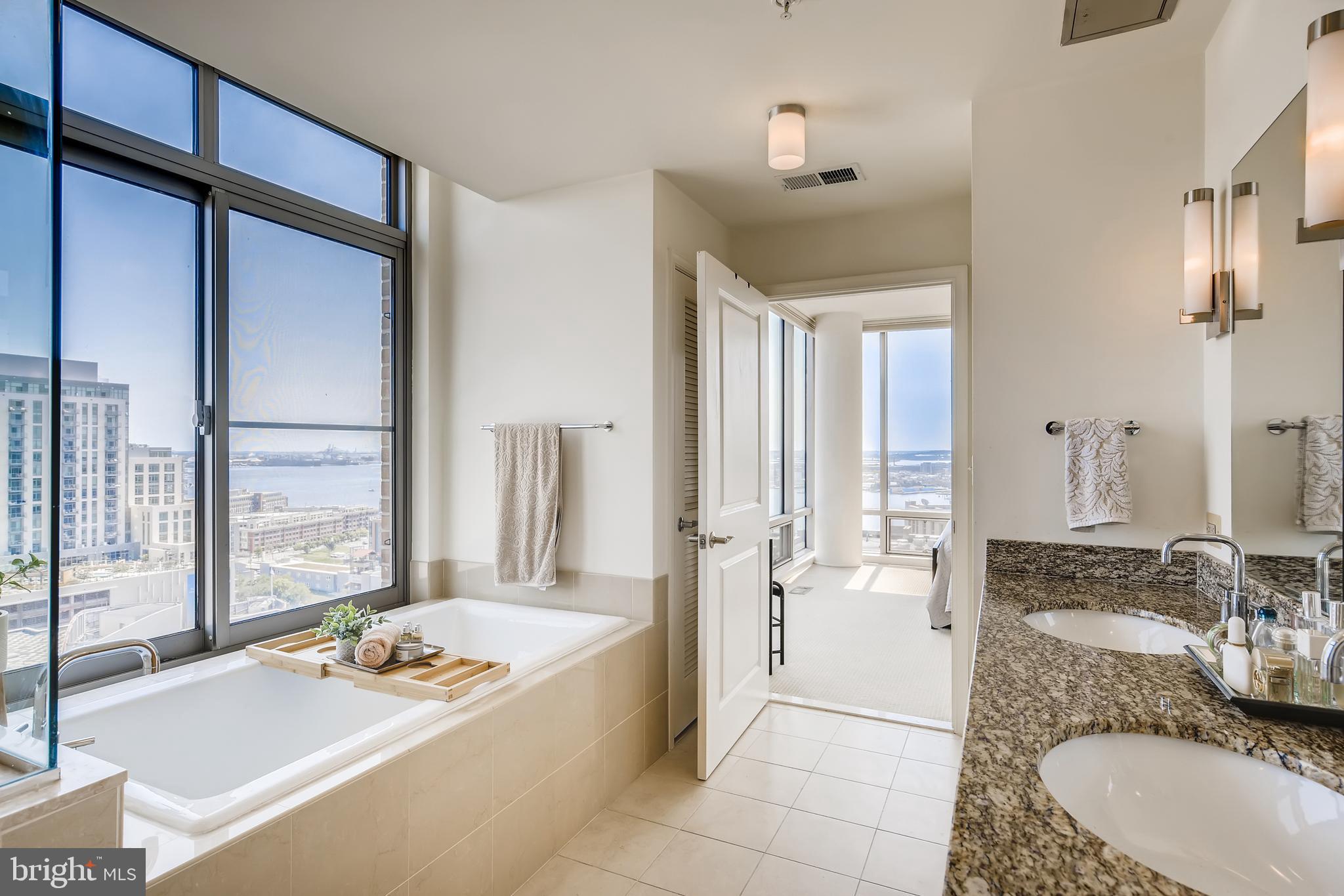 675 President Street, Unit 2105 Baltimore, MD 21202 - Photo 21 of 40 a spacious bathroom with a granite countertop tub sink and mirror