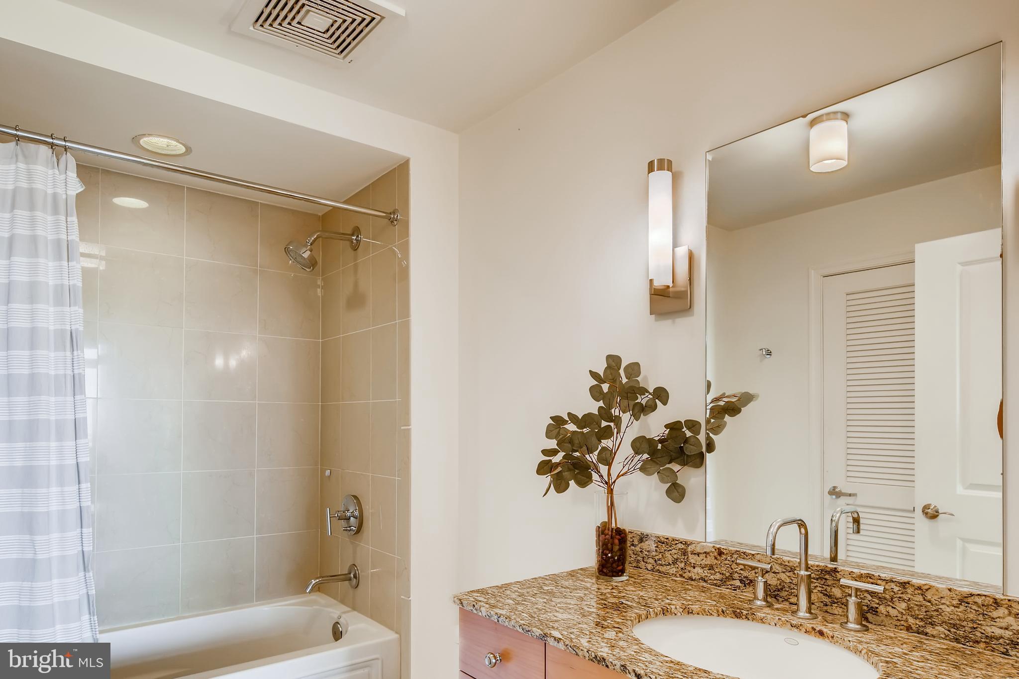675 President Street, Unit 2105 Baltimore, MD 21202 - Photo 24 of 40 a bathroom with a granite countertop shower sink and mirror