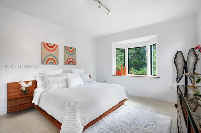 a bedroom with a bed and a dresser with rug