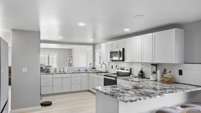 a bathroom with a granite countertop sink and a window