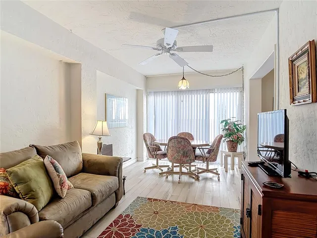a living room with furniture a wooden floor and a flat screen tv