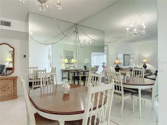 a dining room with furniture a chandelier and wooden floor