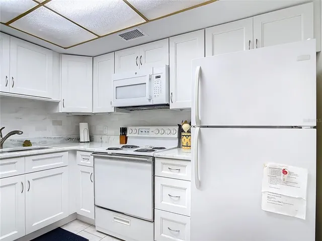 a kitchen with stainless steel appliances white cabinets and wooden floors