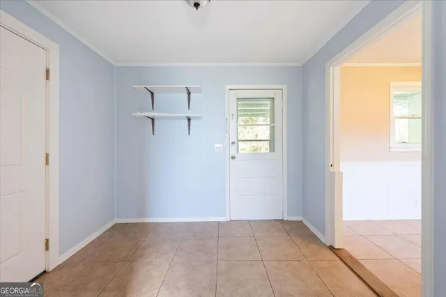 an empty room with wooden floor and fan