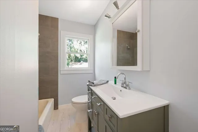 a view of a room with wooden floor a chandelier fan and windows