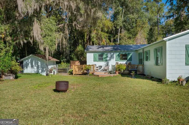 a view of a house with backyard and a tree