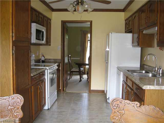 3734 Fieldview Road Pleasant Garden, NC 27313 - Photo 11 of 16 Kitchen. The dining room is right off the kitchen, the fireside den is to the right, and the laundry/mud room & garage are to the left.
