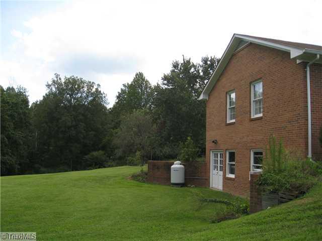 3734 Fieldview Road Pleasant Garden, NC 27313 - Photo 4 of 16 Exterior Front. Left side of the home shows the walk out basement, also accessible from the main level hallway. The basement is approximately 960 sq ft, currently used as a canning facility with a new gas range & double SS sink.
