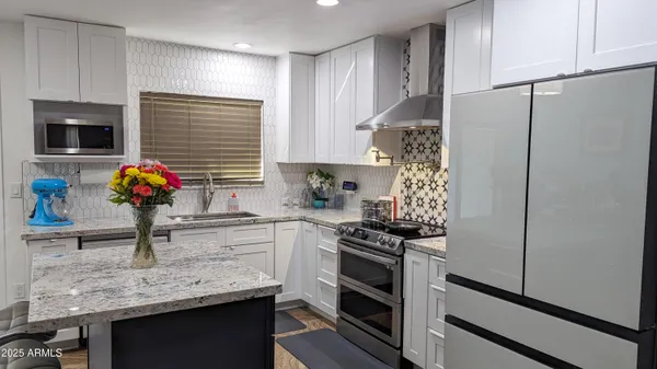 a kitchen with stainless steel appliances a stove refrigerator and microwave