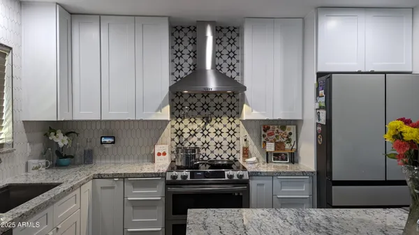 a kitchen with a stove and white cabinets