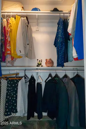 a view of walk in closet with clothes and shoes