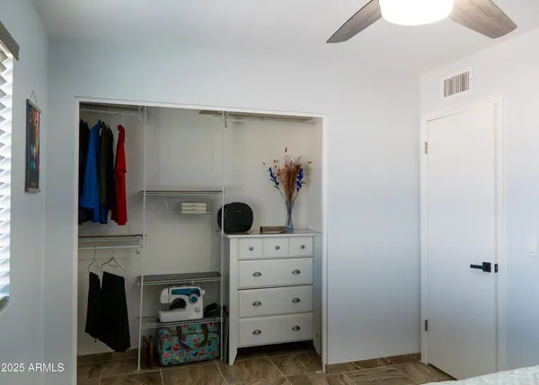 a room with a walk in closet and a mirror