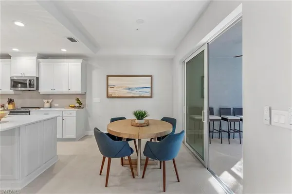 a kitchen with a dining table chairs and refrigerator