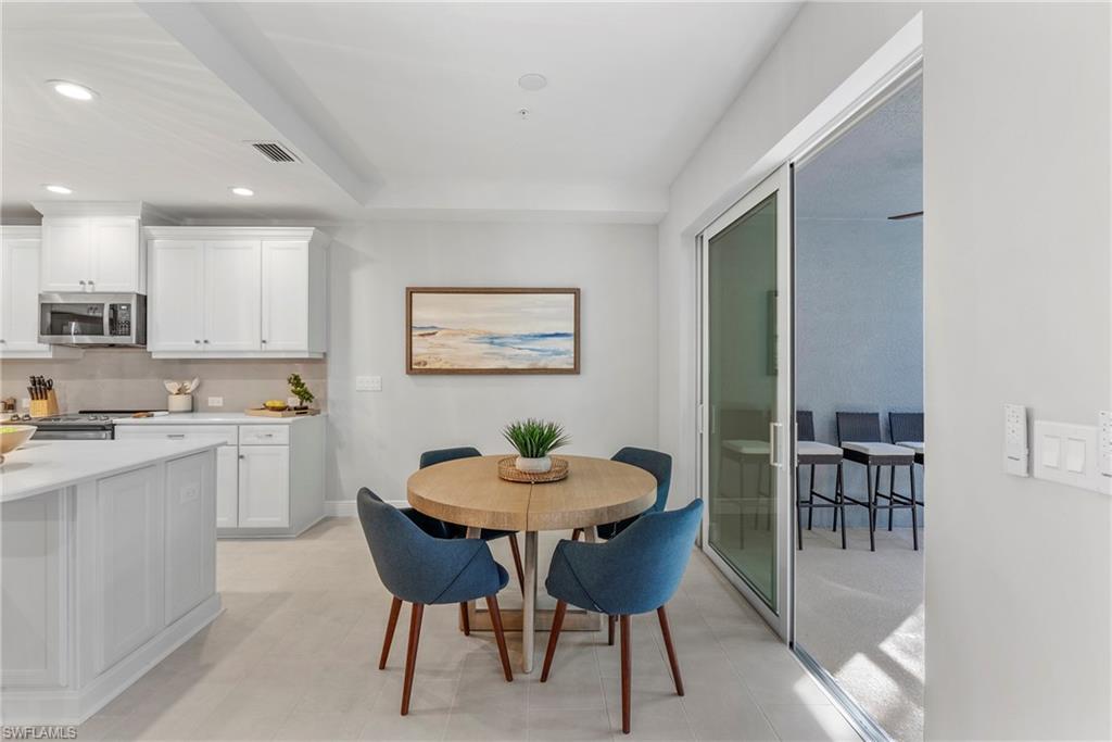 2640 Seychelles Circle, Unit 2802 Naples, FL 34112 - Photo 11 of 32 a kitchen with a dining table chairs and refrigerator