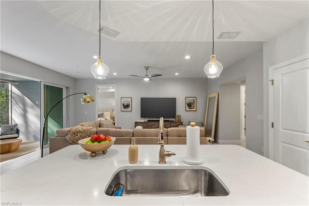 2640 Seychelles Circle, Unit 2802 Naples, FL 34112 - Photo 16 of 32 a kitchen with a sink a counter and living room view