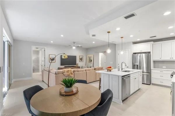 a kitchen with stainless steel appliances kitchen island granite countertop a sink a refrigerator and a stove