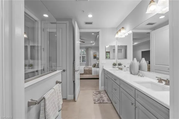 a spacious en suite bathroom with a double vanity sink and mirror