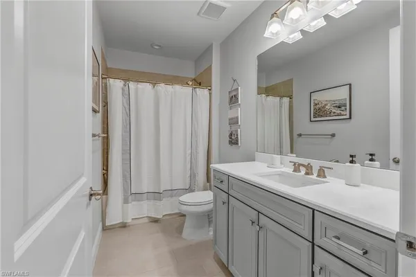 a bathroom with a sink a toilet and a large mirror