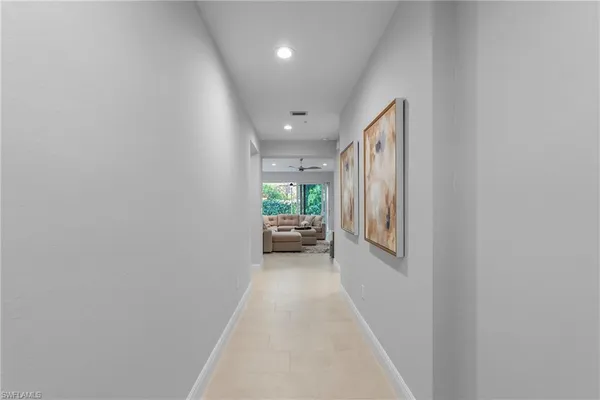 a hallway with a white walls and furniture