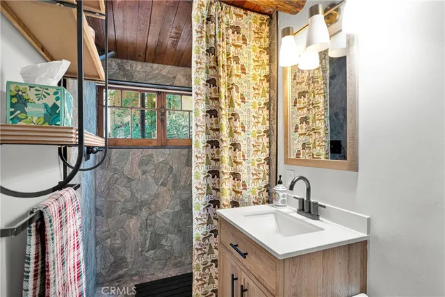 a bathroom with a sink a vanity and a shower curtain