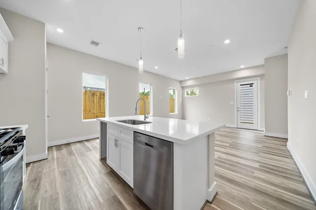 a kitchen with a sink and wooden floor