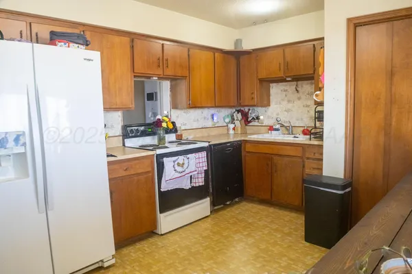 a kitchen with a sink a refrigerator a stove a washer dryer and cabinets