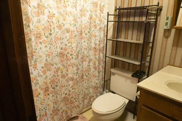 a white toilet sitting next to a shower curtain