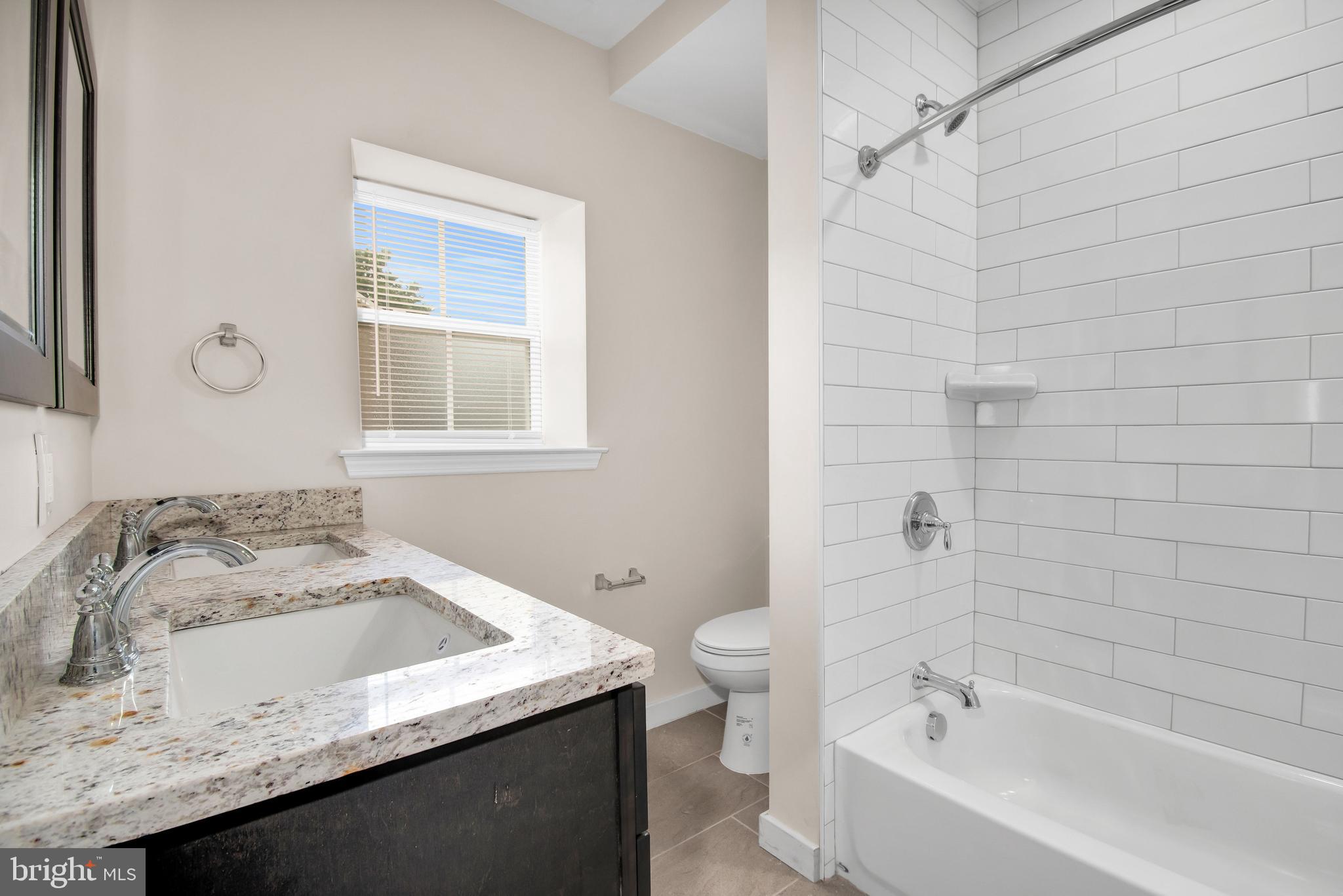 202 Foundry Street Florence, NJ 08518 - Photo 15 of 22 a bathroom with a granite countertop sink and a bathtub
