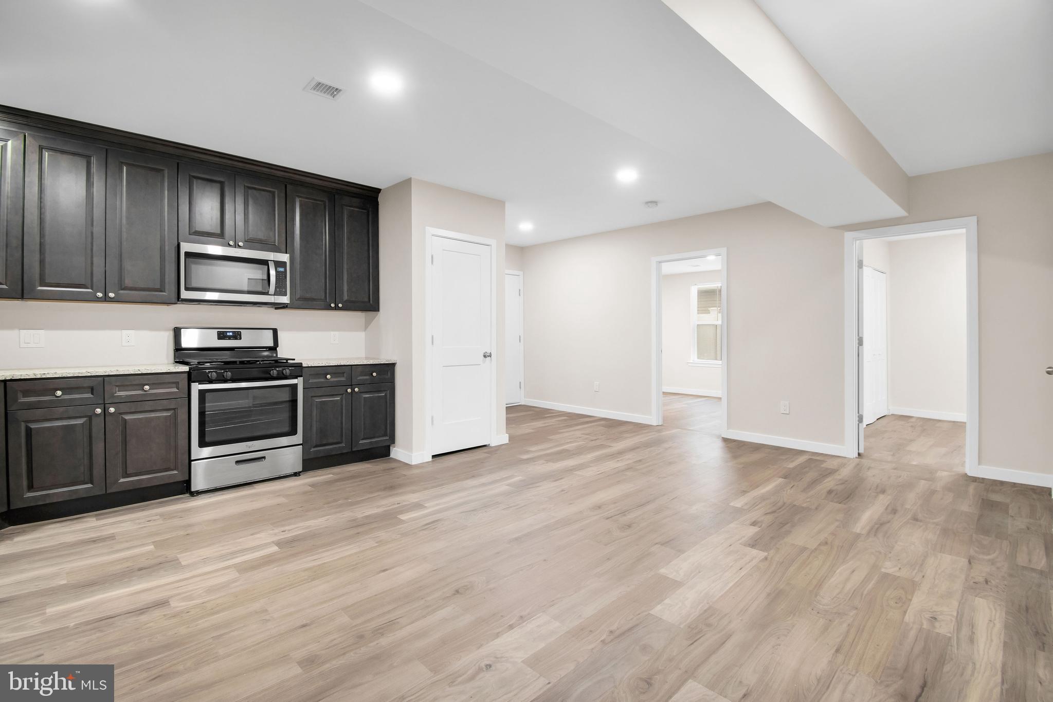 202 Foundry Street Florence, NJ 08518 - Photo 9 of 22 a kitchen with stainless steel appliances a stove a sink and a refrigerator with wooden floor