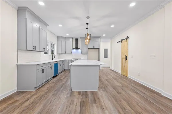 a large kitchen with stainless steel appliances granite countertop a lot of counter space and wooden floors