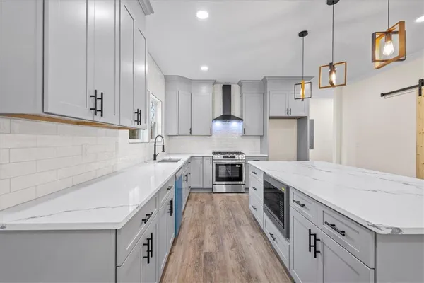 a kitchen with stainless steel appliances granite countertop a sink stove and cabinets