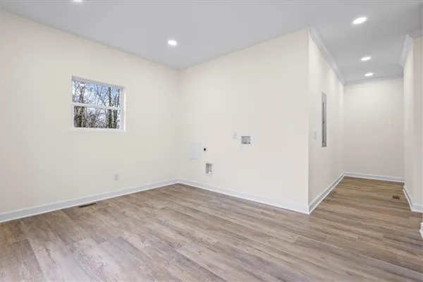 an empty room with wooden floor and windows