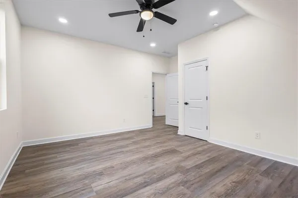 a view of a hallway with wooden floor and closet area